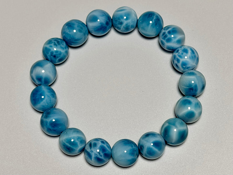 Larimar bracelet, 12 mm, top view showing blue color, white marbling, and bead arrangement.