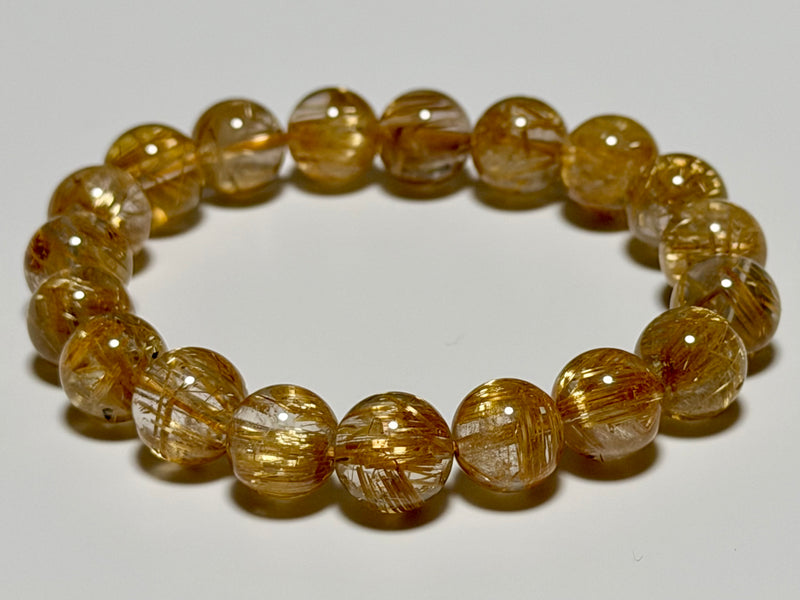 Taichin Golden Rutilated Quartz bracelet, 10 mm, translucency-focused type, full view showing gold rutile needles and quartz translucency.
