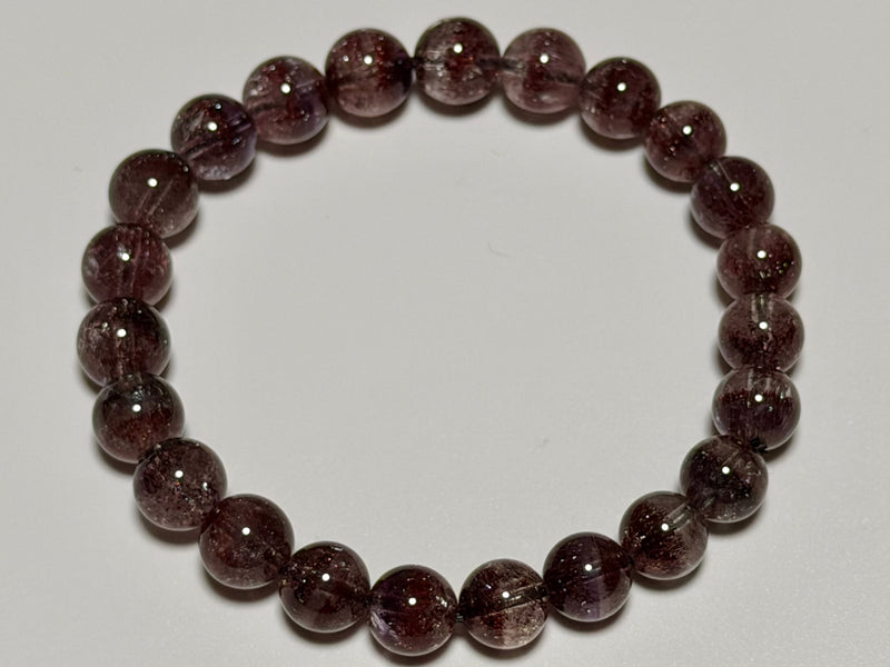 Hanabi Super Seven Quartz bracelet, 8–8.5 mm, top view showing natural inclusions and bead arrangement.
