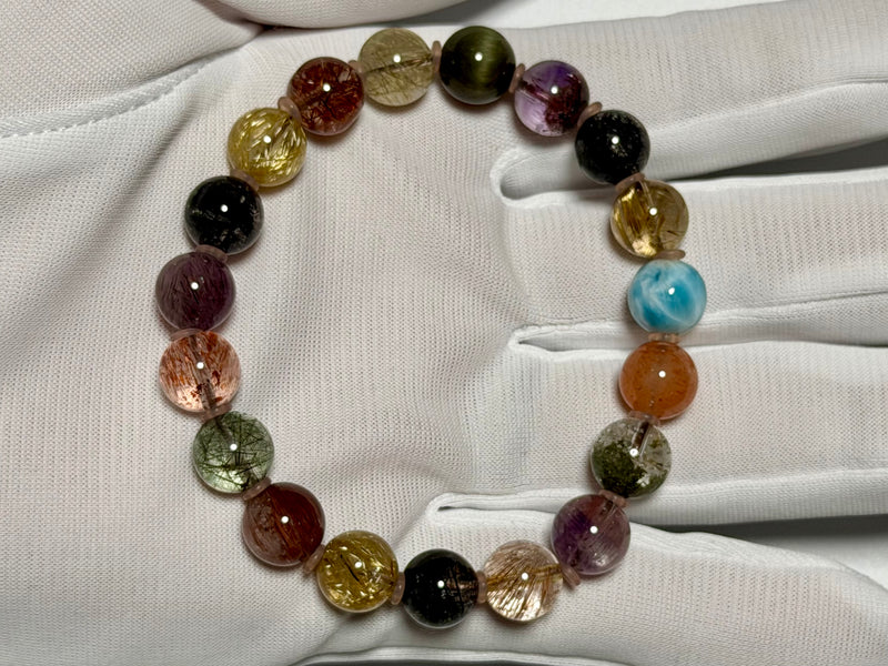 9 mm bracelet with Larimar, Super Seven Quartz, and multicolor rutilated quartz, shown in a gloved hand.